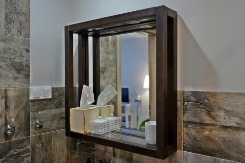 a mirror on a wall in a bathroom at Apartament Parkowy in Nałęczów