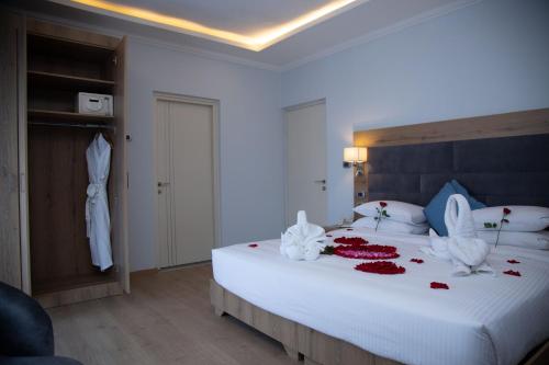 a bedroom with a large white bed with flowers on it at Aselefech Merga Hotel and Spa in Addis Ababa