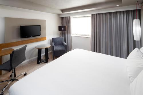 a hotel room with a bed and a desk and a tv at Crowne Plaza Harrogate by IHG in Harrogate