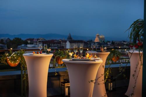 a row of white tables on a balcony with lights at Grand Hotel Sofia in Sofia