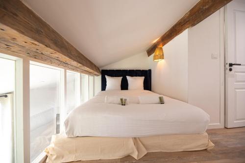 une chambre avec un grand lit avec des draps blancs dans l'établissement Loft in paris, à Paris