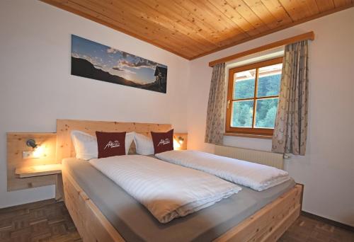een slaapkamer met een groot bed en een raam bij Alpboden in Auffach