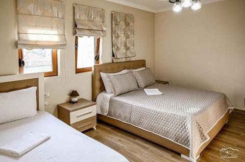 a small bedroom with two beds and a window at Vila Leo Lux in Korçë