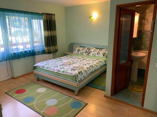 a small bedroom with a bed and a window at Vila Andra in Azuga