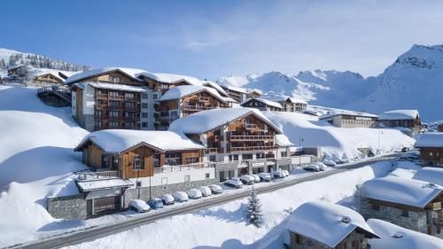 a resort in the snow with snow covered buildings at ILY Hotels & Spa La Rosiere in La Rosière
