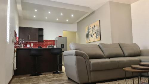 a living room with a couch and a kitchen at Platinum Apartment in Polokwane