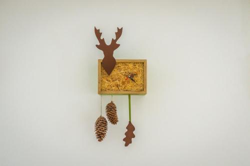 a clock on a wall with two pine cones at MINAROSO appartements am badeparadies in Titisee-Neustadt