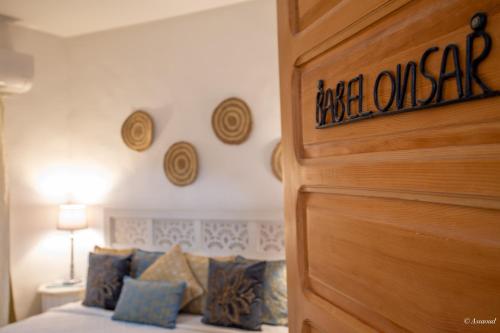a bedroom with a bed and a wooden door at Riad Nila in Chefchaouene