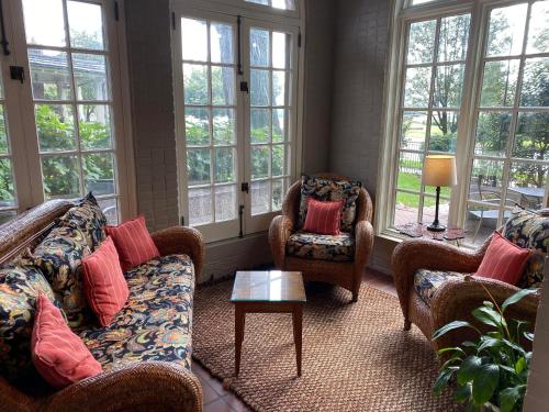a living room with couches and chairs and windows at City House Bed and Breakfast in Harrisburg