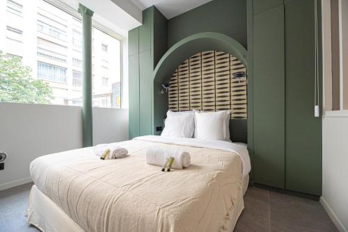 a bedroom with a large bed with two towels on it at MBM - CHEMIN VERT in Paris