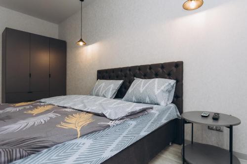 a bedroom with a bed and a night stand next to it at Apart Lux Elegant in Sumy