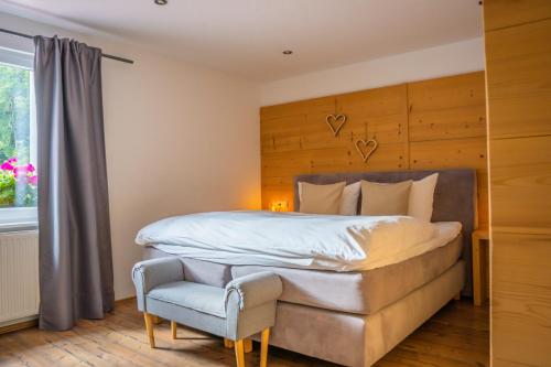 a bedroom with a large bed and a chair at MINAROSO appartements am badeparadies in Titisee-Neustadt