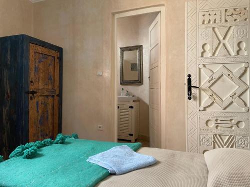 a bedroom with a bed and a door and a mirror at Taghazout Ocean View in Taghazout