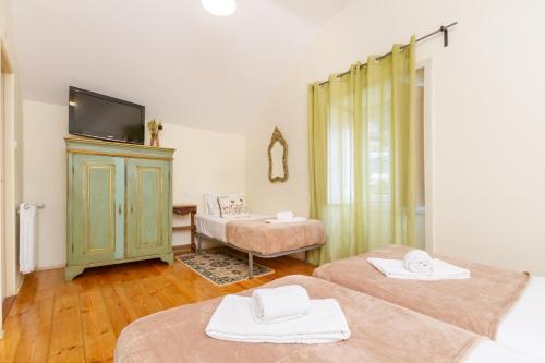 a room with two beds and a television in it at Quinta Das Murtas B&B in Sintra