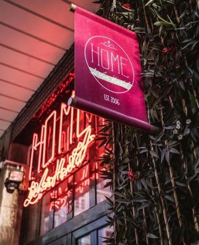 a sign on the side of a building with neon signs at Home Lisbon Hostel in Lisbon