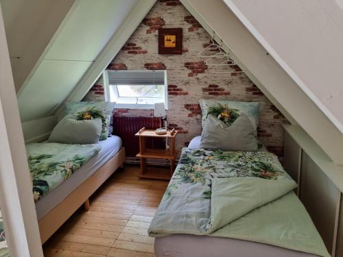 Cette chambre mansardée comprend deux lits et un escalier. dans l'établissement Belle-Swan, à Simpelveld