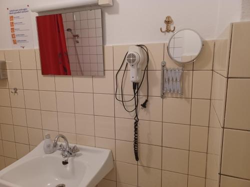 a bathroom with a hair dryer hanging on the wall at Zum Fuchsbau in Niederhövels
