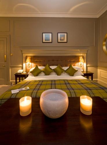 a bedroom with a bed with two candles on a table at Isle of Eriska Hotel Spa & Island in Benderloch