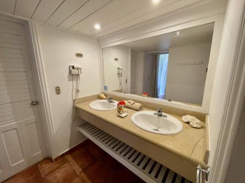 a bathroom with two sinks and a large mirror at bungalow 3116 vue sur piscine in Las Galeras