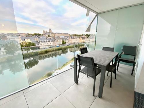 a table and chairs on a balcony with a view of the water at Presqu'île de Caen, Terrasse & Parking in Caen