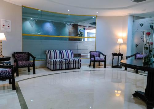 a waiting room with a couch and chairs at Hotel Internacional La Triada in Bucaramanga
