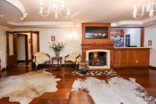 a living room with a fireplace and a chandelier at Hotel Kehl Haus in Gramado