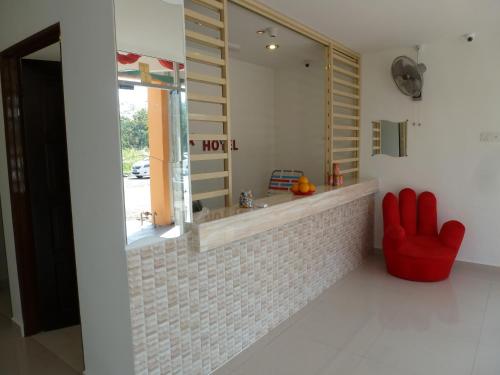 a living room with a red chair and a window at RELAX HOTEL in Sungai Petani