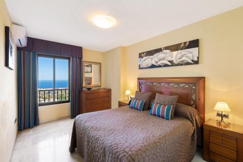 - une chambre avec un lit et une vue sur l'océan dans l'établissement Macdonald La Ermita Resort, à Mijas