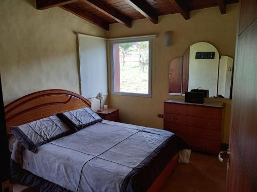 um quarto com uma cama, uma janela e uma cómoda em Lo de Ely em Tafí del Valle