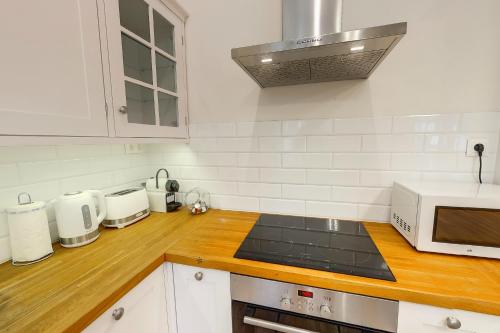 a kitchen with white appliances and a wooden counter top at Romantic riverview Bestern in Szeged