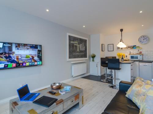 a living room with a couch and a table with a laptop at Central Belfast Apartments Alfred Street in Belfast