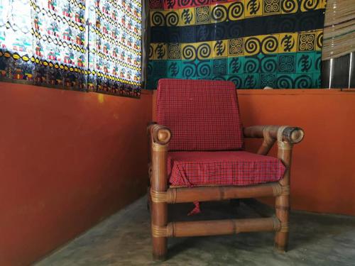 a red chair sitting in a corner of a room at A&Y Wild Camp Ghana in Keta
