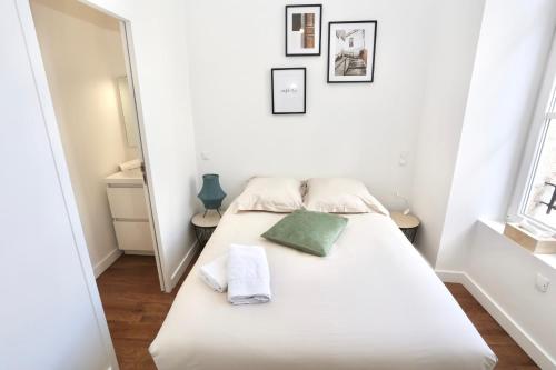 - une chambre avec un lit blanc et un oreiller vert dans l'établissement Napoléon Gare 6 T2 1er etage ByLocly, à Pontivy