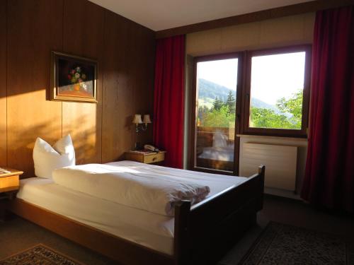 a bedroom with a large bed and a window at Pension Mühlbachhof in Alpbach