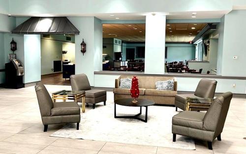 a lobby with a couch and chairs and a table at Clarion Inn & Suites Florence - Darlington in Florence