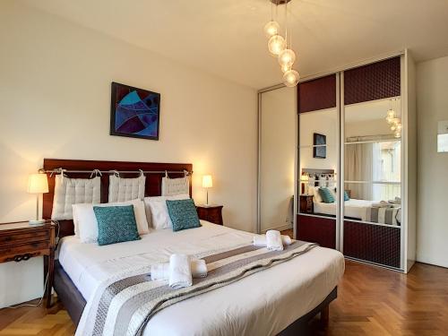 une chambre avec un grand lit avec des oreillers bleus dans l'établissement Nestor&Jeeves - ANDRIOLI TERRASSE - Central - Close beach - Top floor, à Nice