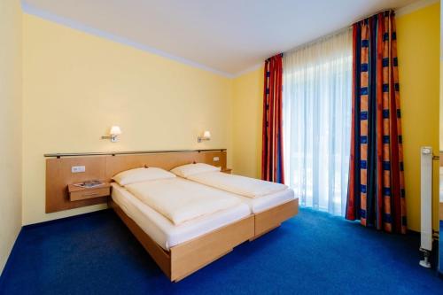 a bedroom with a large bed and a window at Hotel Graf Lehndorff zur Messe in Munich