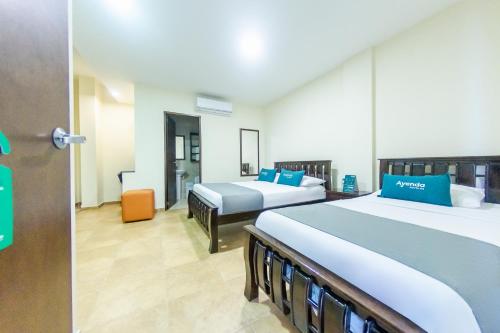 a room with two beds in it with a door open at Hotel El Viajero #2 in Cartagena de Indias