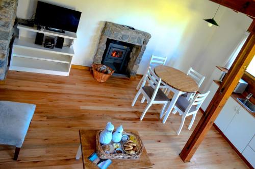 a living room with a table and a fireplace at El Montenegrino in Tandil