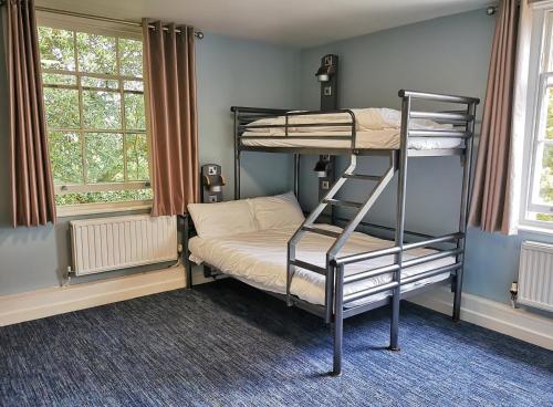 a bedroom with two bunk beds and two windows at YHA Stratford-Upon-Avon in Stratford-upon-Avon