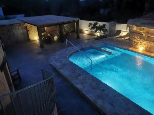 a swimming pool at night with a table and a swimming pool at Apartamentos Montgò in Denia