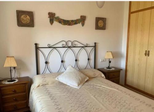 a bed in a bedroom with two night stands and two lamps at Dehesa de Campoamor in Orihuela