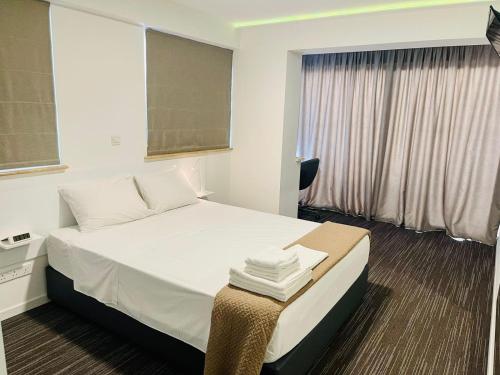 Nicosia 5 Stars Suites tesisinde bir odada yatak veya yataklar