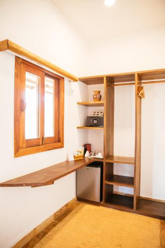 a kitchen with a wooden counter and a window at CasaLô Hotel in Jericoacoara