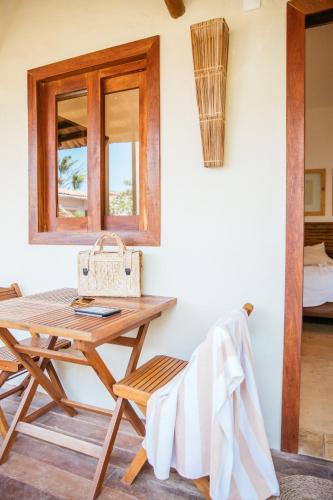 a table and chair in a room with a window at CasaLô Hotel in Jericoacoara