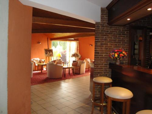 a restaurant with stools and tables and chairs at Hotel Le Drakkar in Pont-Audemer