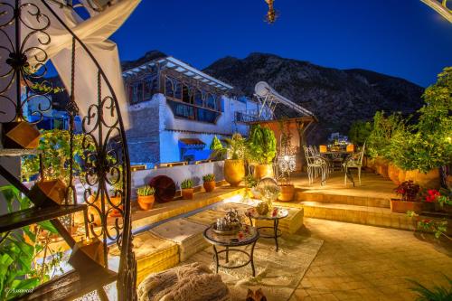 a house with a patio with a table and chairs at Riad Nila in Chefchaouene
