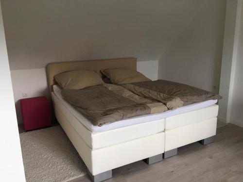 Cama en habitación con marco de cama blanco en Dachgeschosswohnung in Ranstadt, en Ranstadt