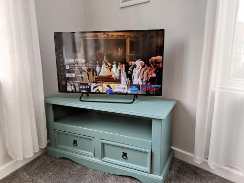 a blue dresser with a tv on top of it at Spacious contemporary apartment in Ramsgate