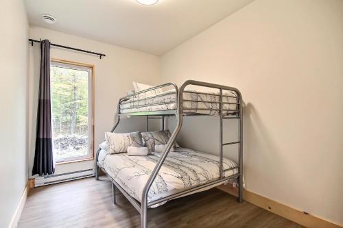 a bunk bed in a room with a window at Sutton Wellness Cabin #265 unité du haut in Sutton